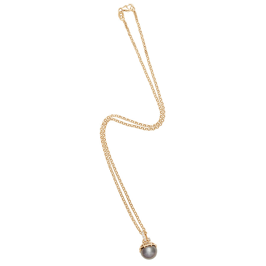 Full view of a one of a kind peacock pearl pendant with white diamond pave on the top and grey diamond accent stones on either side on a yellow gold chain.