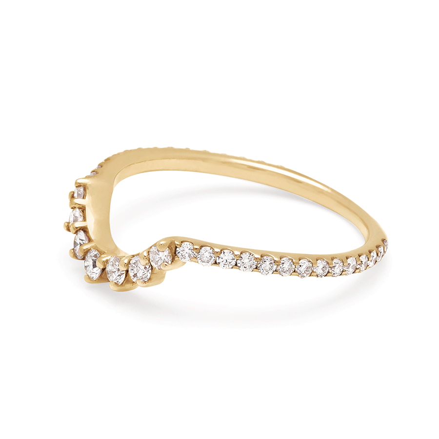 Angled view of a curve band with 7 white diamonds at the center and white diamond pave around the rest of the band set in yellow gold.