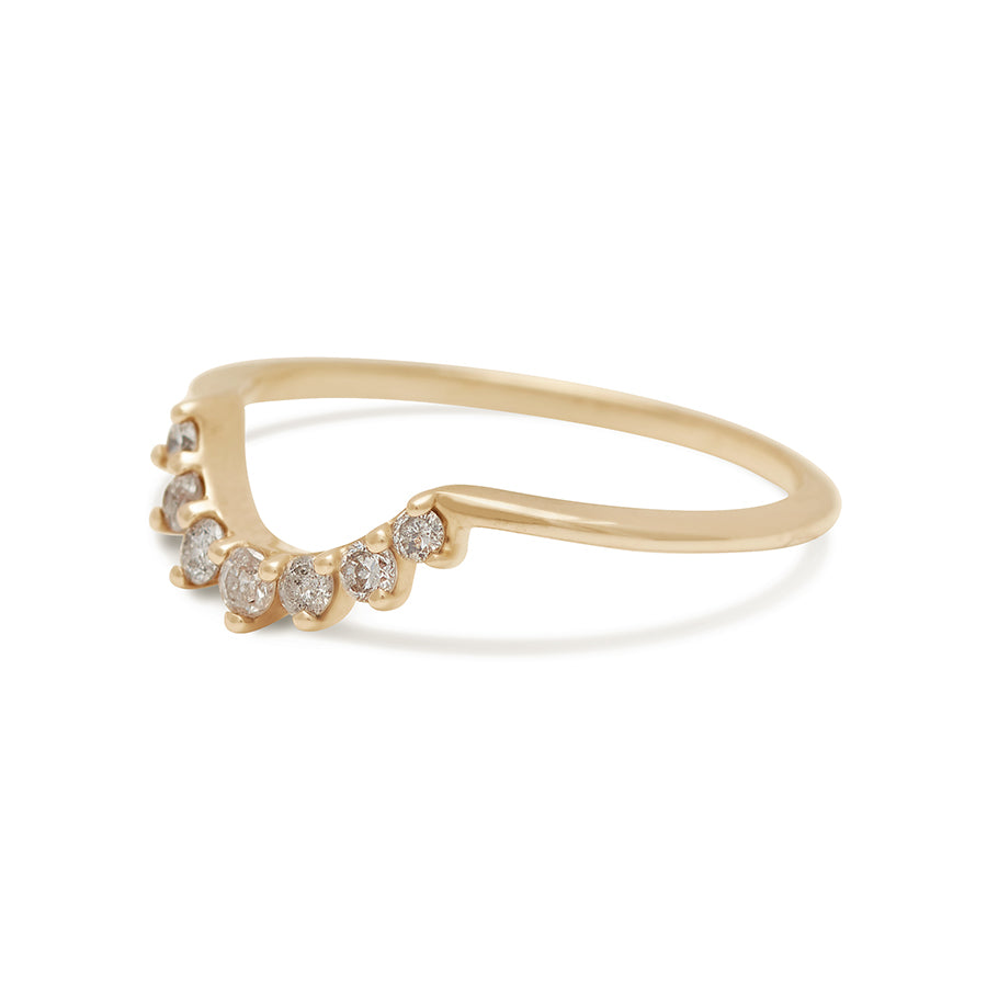 Angled view of a curve band with 7 grey diamonds set in yellow gold.