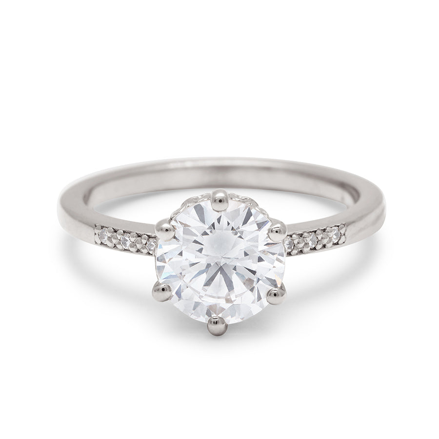 A solitaire ring with a round brilliant cut 1.50ct white diamond with white diamond pave on either side set in white gold., White Gold