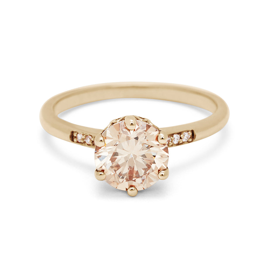A solitaire ring with a round 1.50ct champagne diamond with white diamond pave on either side set in yellow gold., Yellow Gold