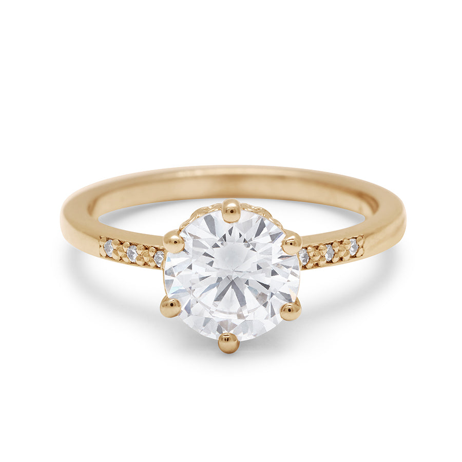 A solitaire ring with a round brilliant cut 1.50ct white diamond with white diamond pave on either side set in yellow gold., Yellow Gold