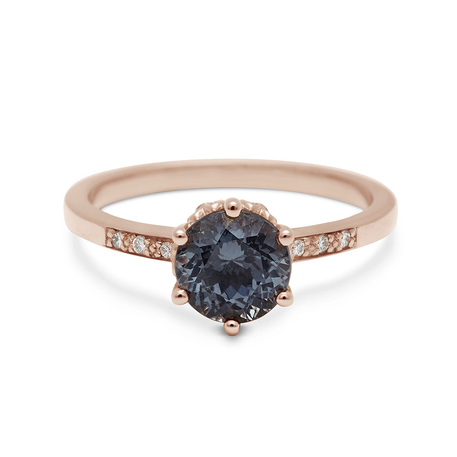 A solitaire ring with a round grey spinel with white diamond pave on either side set in rose gold., Rose Gold