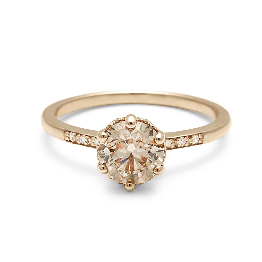 A solitaire ring with a round brilliant cut 1.00ct champagne diamond with white diamond pave on either side set in yellow gold., Yellow Gold