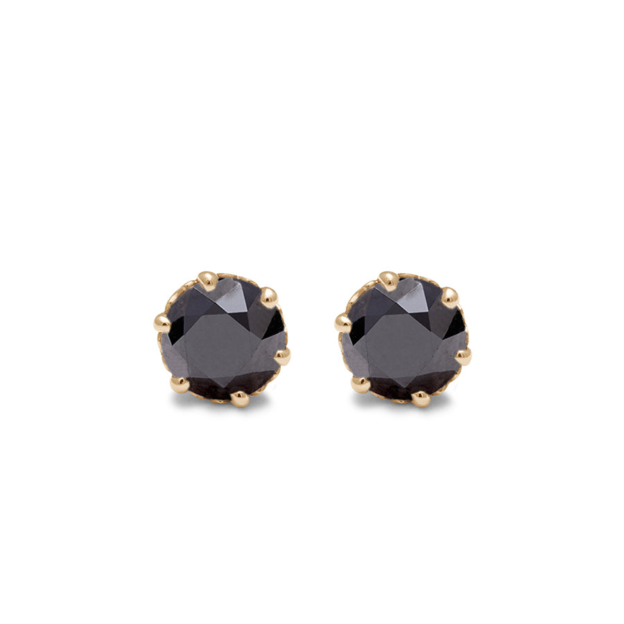 A pair of black diamond stud earrings set in an intricate basket in yellow gold.