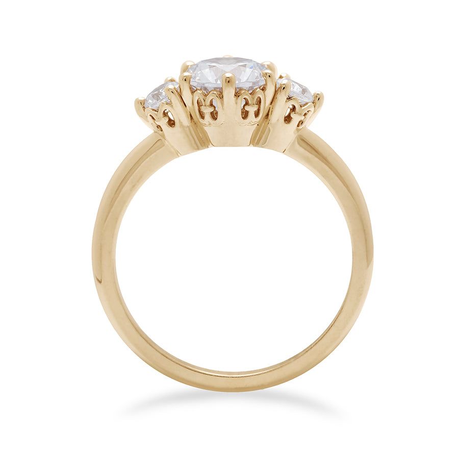 Side view of a three stone engagement ring with a round shape white diamond center stone with two white diamond round side stones set in yellow gold., Yellow Gold