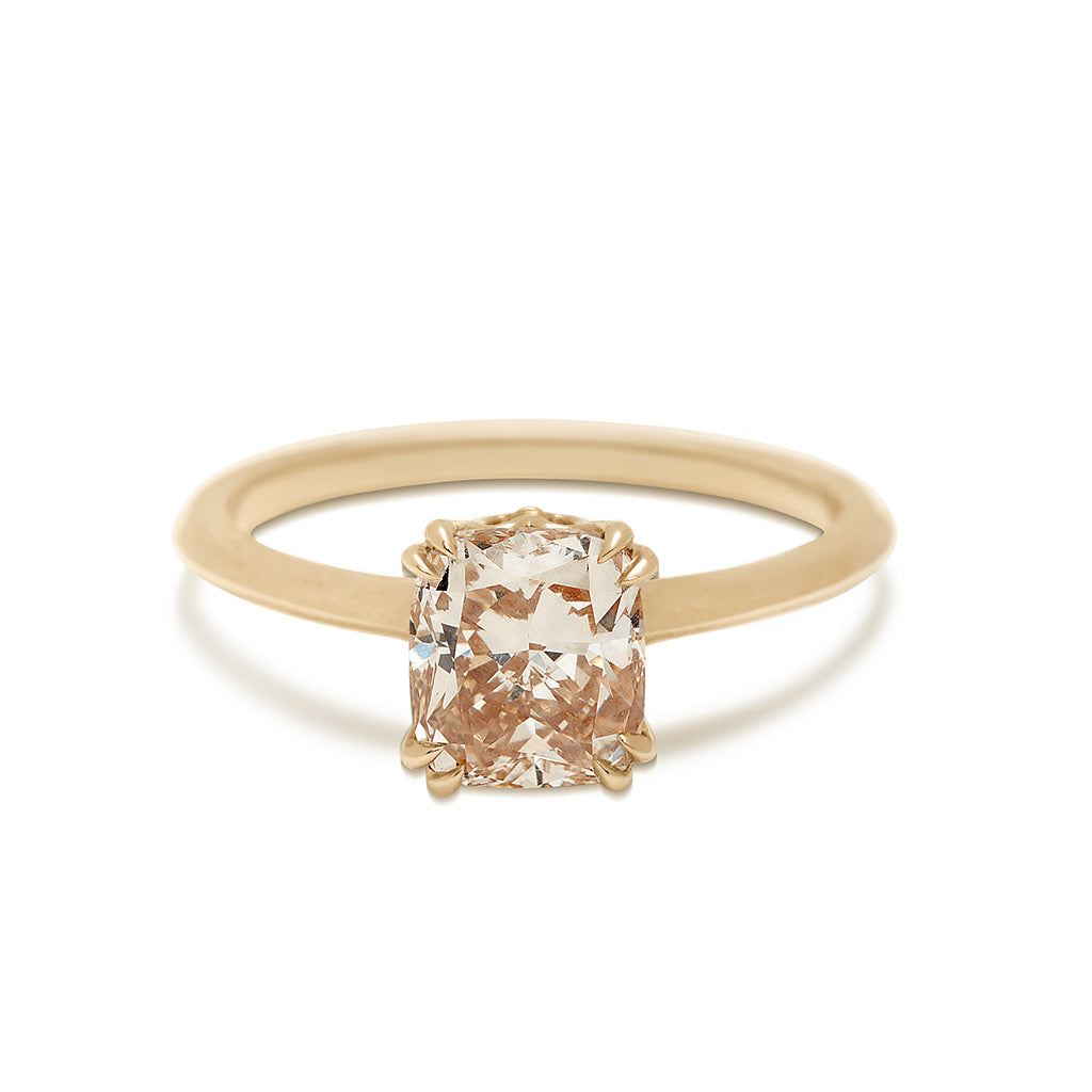 A solitaire ring with a cushion cut 1.50ct champagne diamond set in yellow gold on a knife edge band.