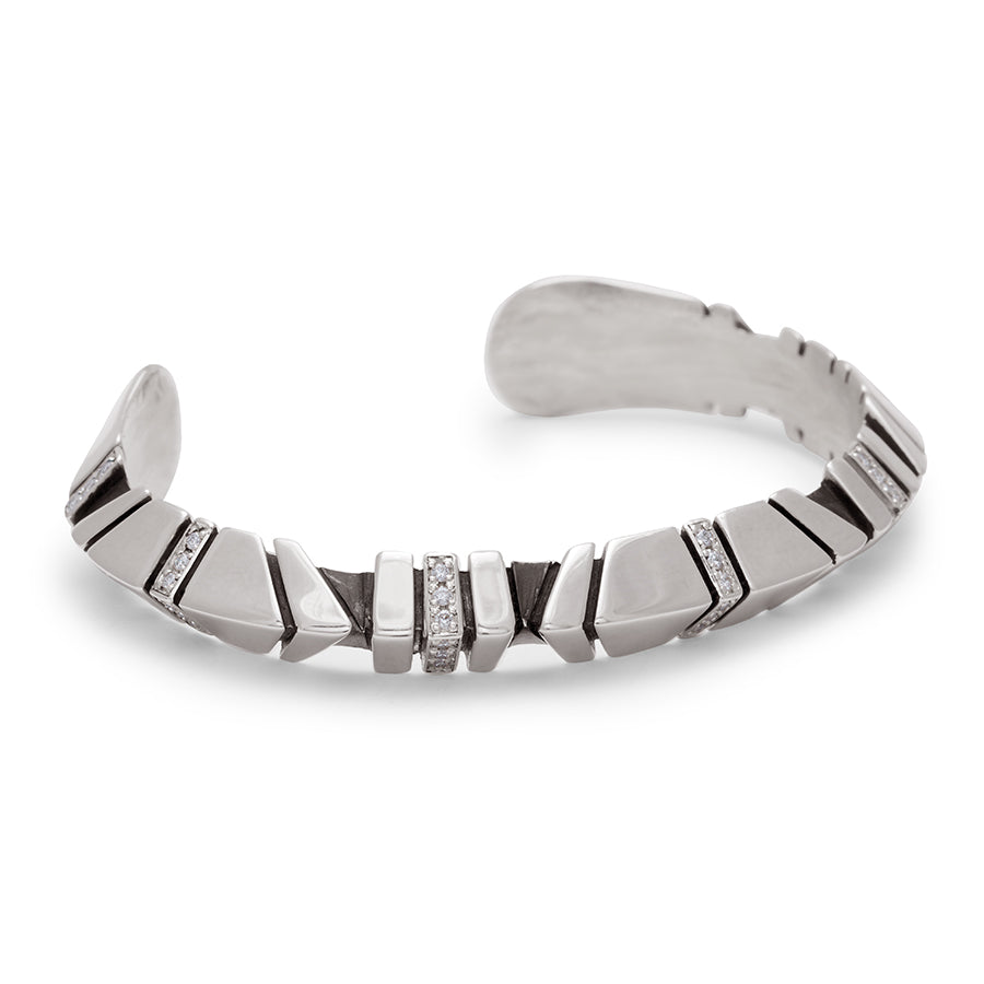 Angled view of a sterling silver cuff with definition and white diamond accent stones.