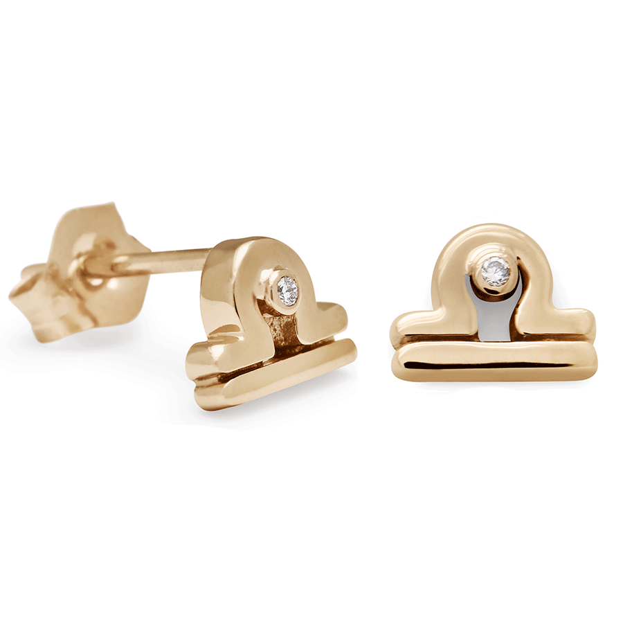 A pair of Libra stud earrings set in yellow gold with a white diamond accent stone with one earring angled.