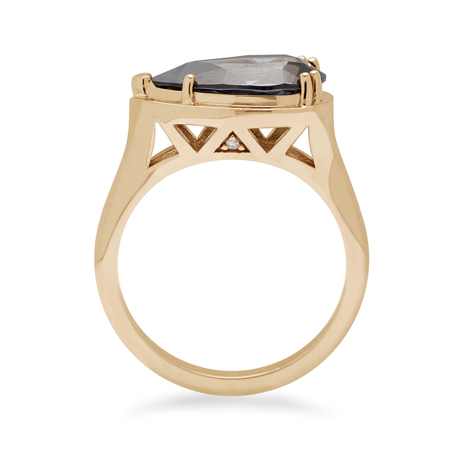 Side view of a solitaire ring pear shaped grey spinel set in yellow gold.