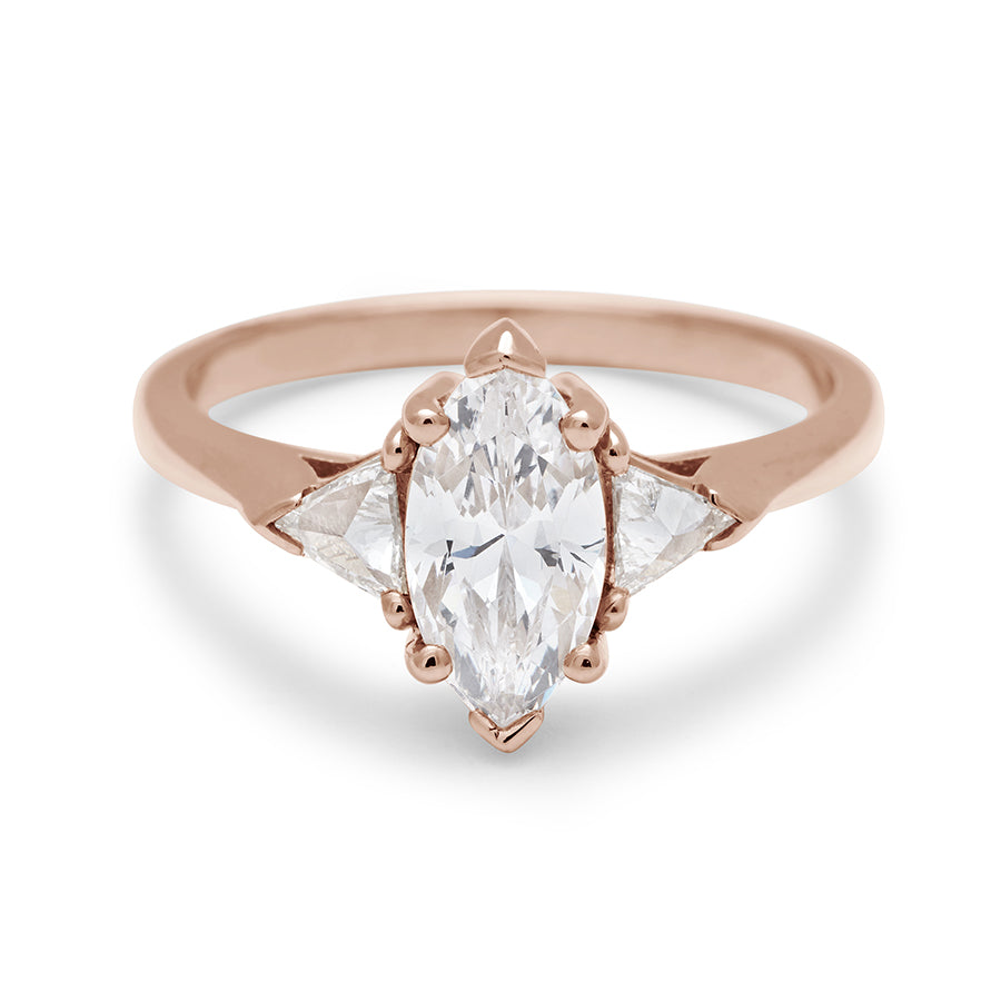 A three stone engagement ring with a marquise shape brilliant cut 1.00ct white diamond center stone with two white diamond trillion side stones set in rose gold., Rose Gold