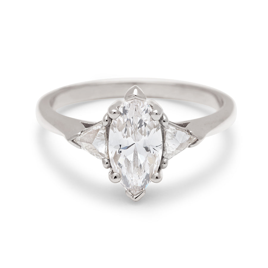A three stone engagement ring with a marquise shape brilliant cut 1.00ct white diamond center stone with two white diamond trillion side stones set in white gold., White Gold