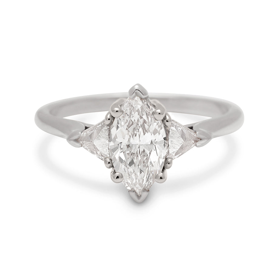 A three stone engagement ring with a 1.25ct marquise shape white diamond center stone with two white diamond trillion side stones set in white gold., White Gold
