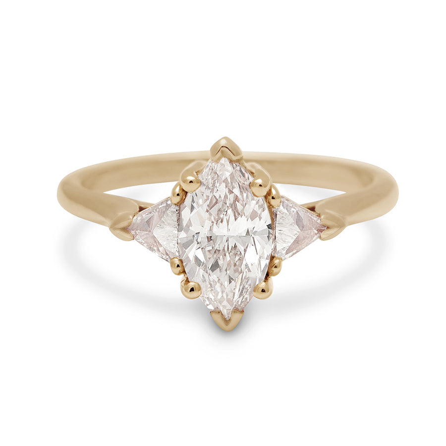 A three stone engagement ring with a 1.25ct marquise shape white diamond center stone with two white diamond trillion side stones set in yellow gold., Yellow Gold