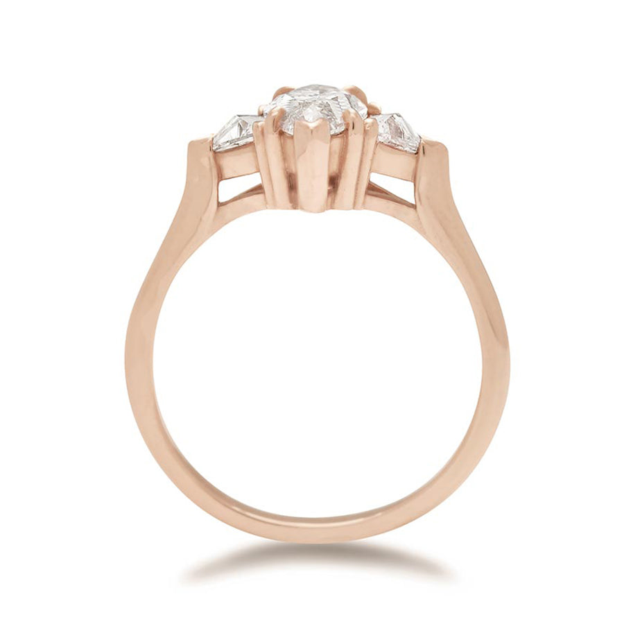 Side view of a three stone engagement ring with a 1.25ct marquise shape white diamond center stone with two white diamond trillion side stones set in rose gold., Rose Gold