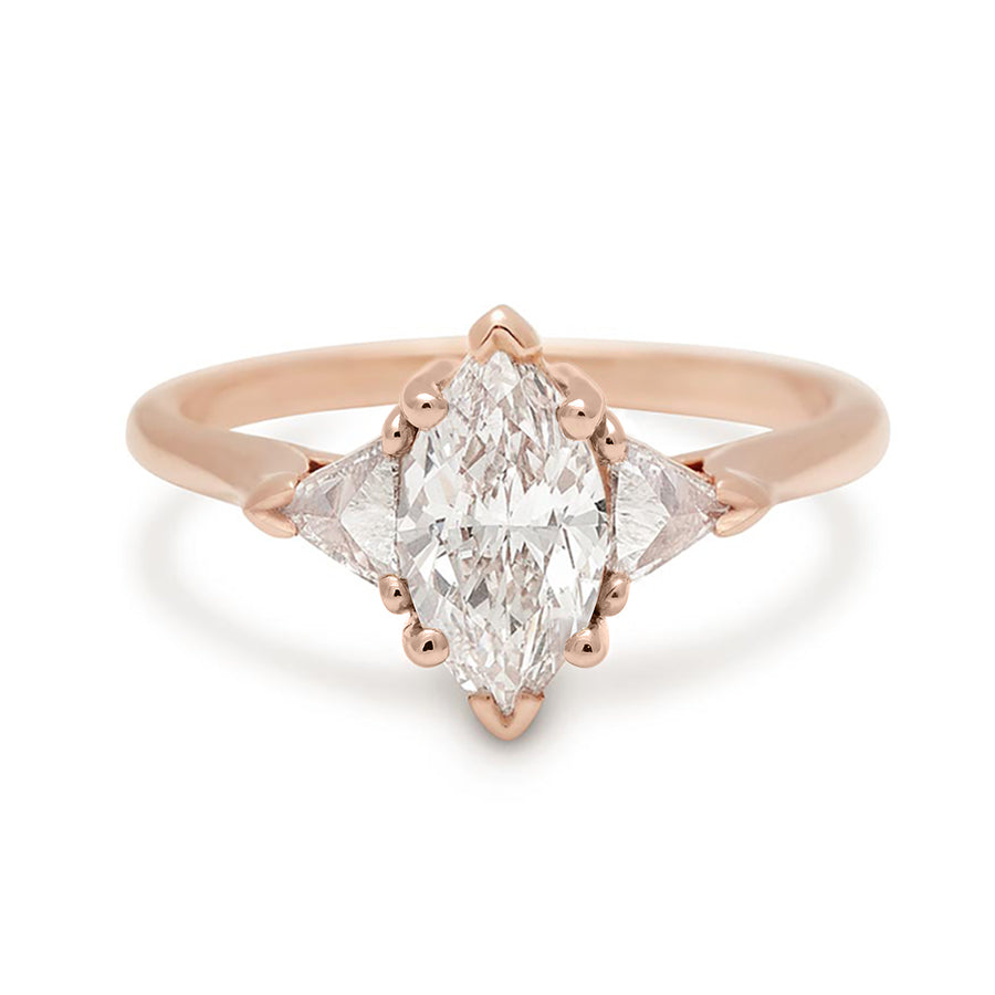 A three stone engagement ring with a 1.25ct marquise shape white diamond center stone with two white diamond trillion side stones set in rose gold., Rose Gold