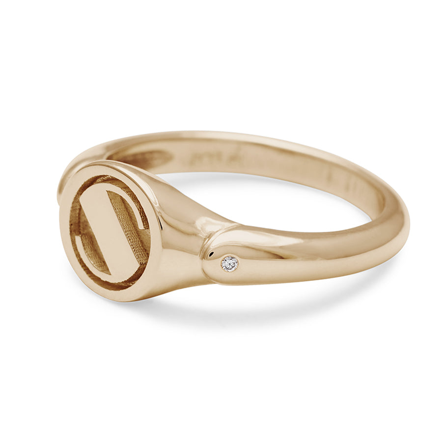 Angled view of a monogrammed signet ring with a "S" on the front and two white diamond accents on either side and set in yellow gold.