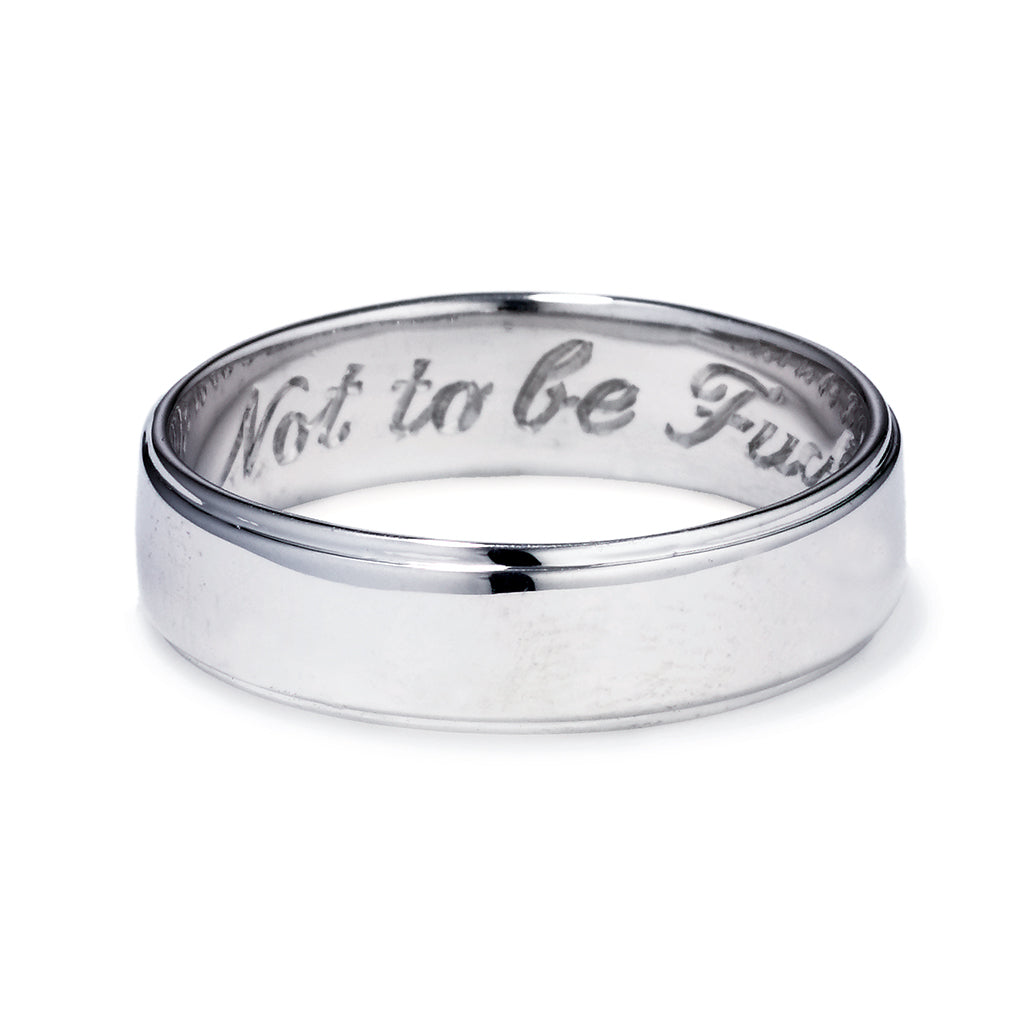 A white gold flat edge band in 5mm with "Not to Be F**ked With" engraved on the inside., White Gold