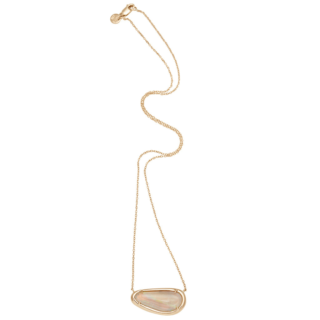 A zoomed out view of a necklace with an opal set in bezel with claw prongs set in yellow gold on a yellow gold chain.