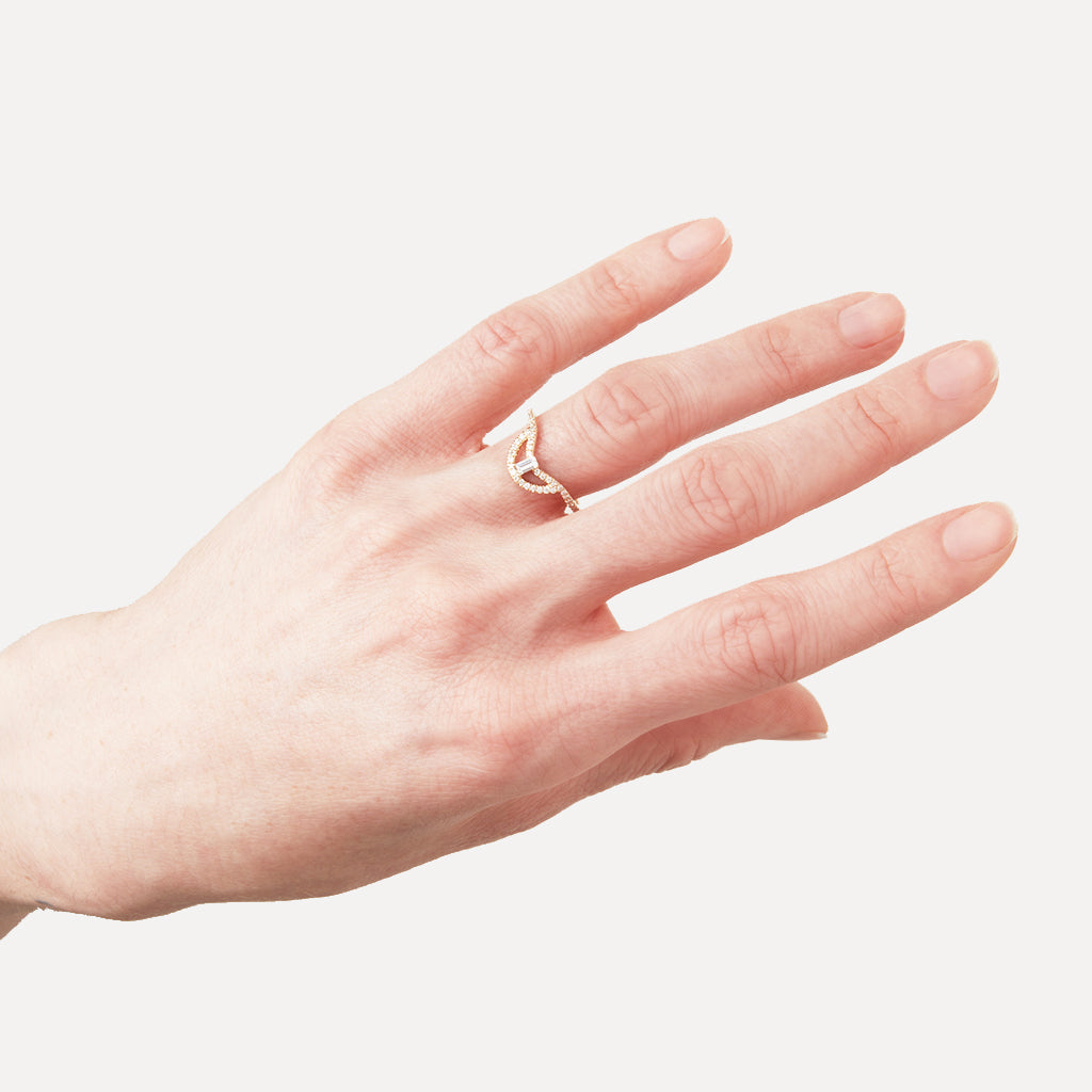 A helios band with a white diamond baguette and white diamond pave set in yellow gold on a light-complextion left hand ring finger. Available in Rose Gold, Yellow Gold, White Gold. 