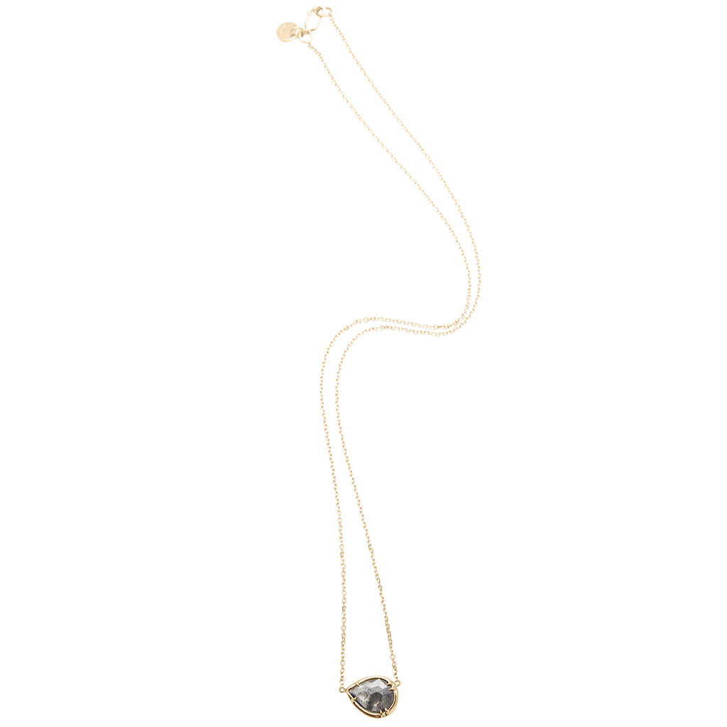 Zoomed view of a pear necklace with a grey diamond set in bezel with claw prongs in yellow gold with a yellow gold chain.
