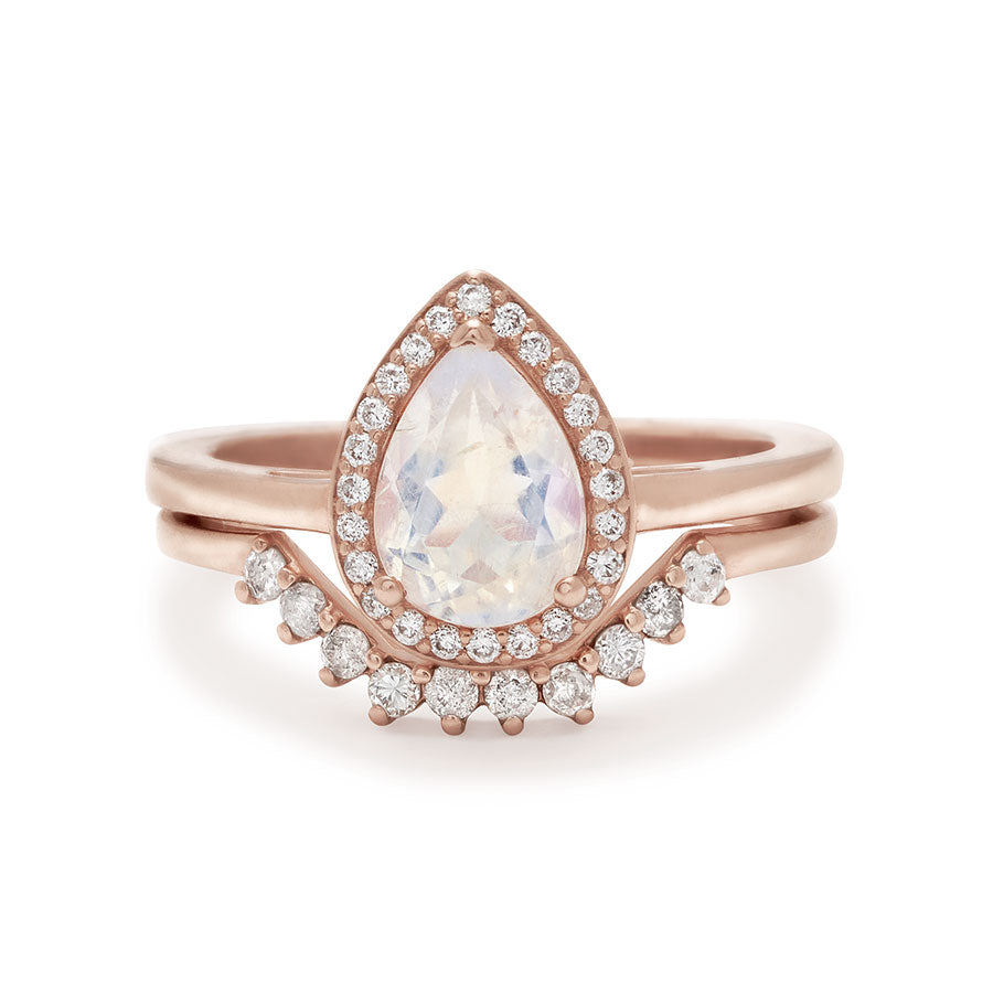 An engagement ring with a pear shape rainbow moonstone center stone surrounded by a white diamond pave halo set in rose gold stacked above a white diamond nesting band., White Gold, Rose Gold, Yellow Gold