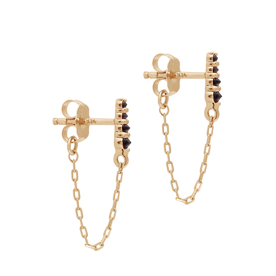 A pair of earrings with four black diamonds with a chain connecting to the ear back set in yellow gold., Yellow Gold