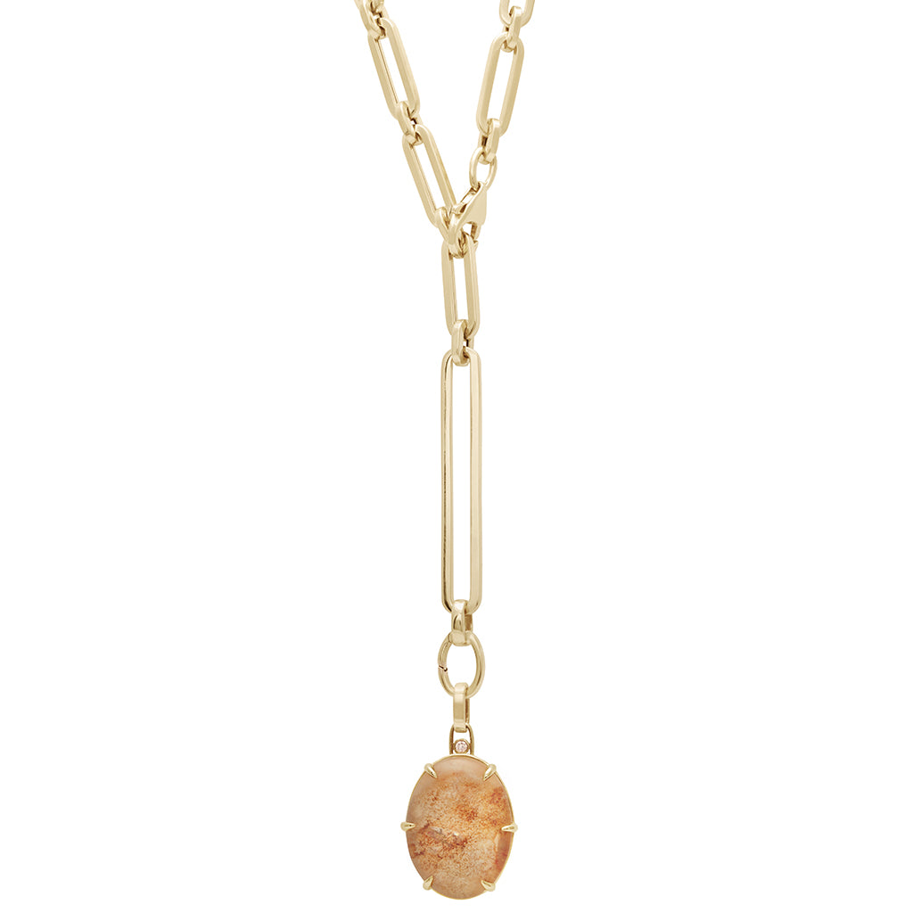 A quartz charm in a bezel setting with claw prongs set in yellow gold with champagne diamond accent stone on a mixed link yellow gold chain.