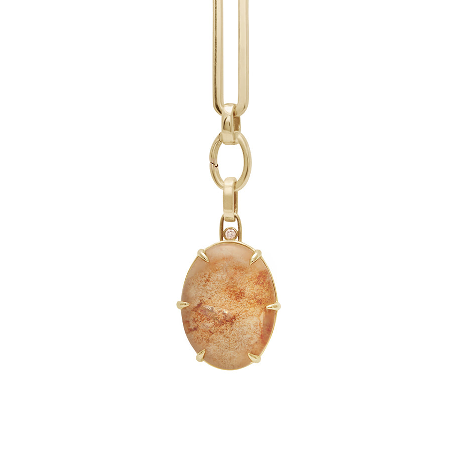 Zoomed in view of a quartz charm in a bezel setting with claw prongs set in yellow gold with champagne diamond accent stone on a mixed link yellow gold chain.