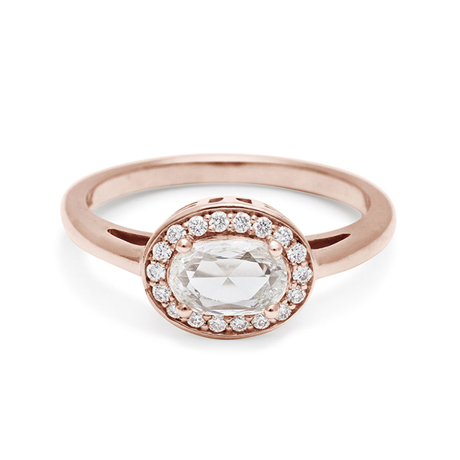 An engagement ring with a rose cut and oval shape white diamond center stone surrounded by a white diamond pave halo set in rose gold., Rose Gold