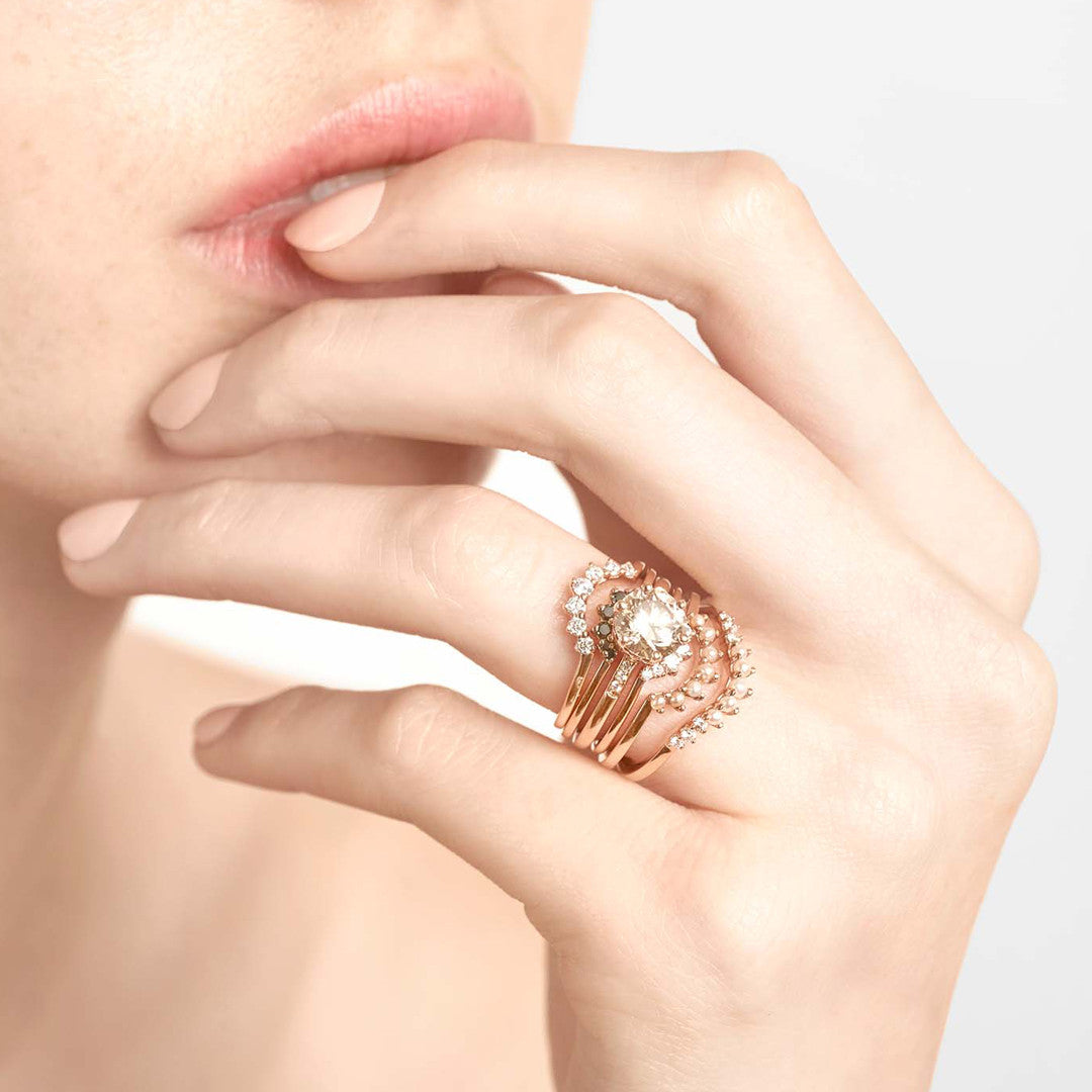 A curve band with 7 white diamonds set in yellow gold stacked above a smaller 7 diamond band, a solitaire champagne diamond engagement ring and three more curved diamond bands in assorted diamonds., White Gold, Rose Gold, Yellow Gold