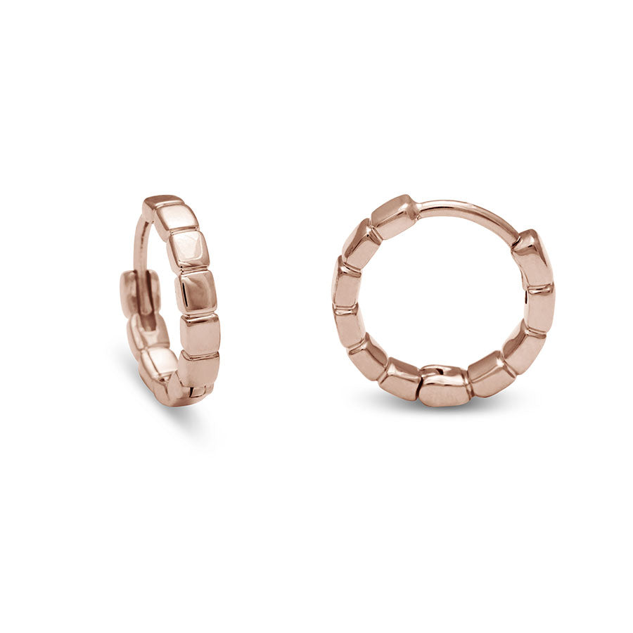 One side and one straight on view of a solid gold pair of huggie hoops set in rose gold.