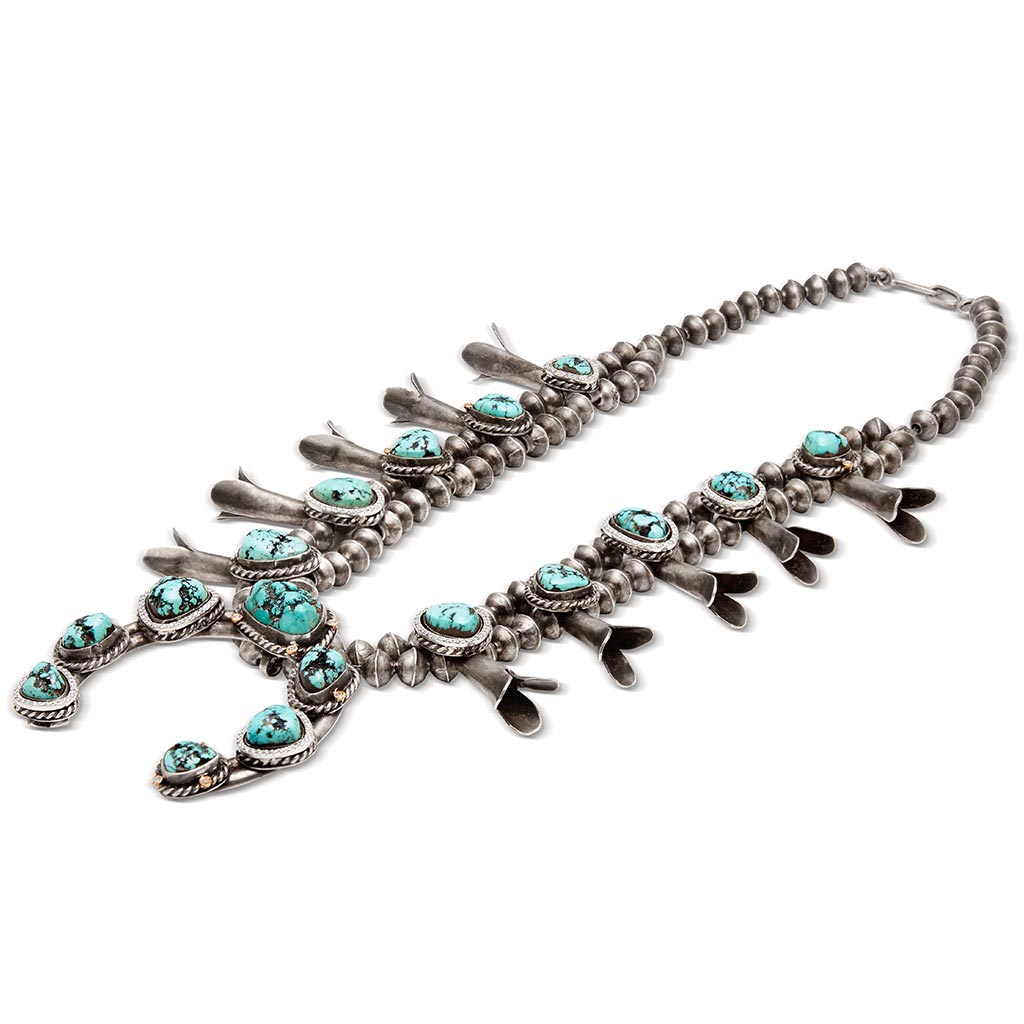A turquoise stone squash blossom necklace set in sterling silver.