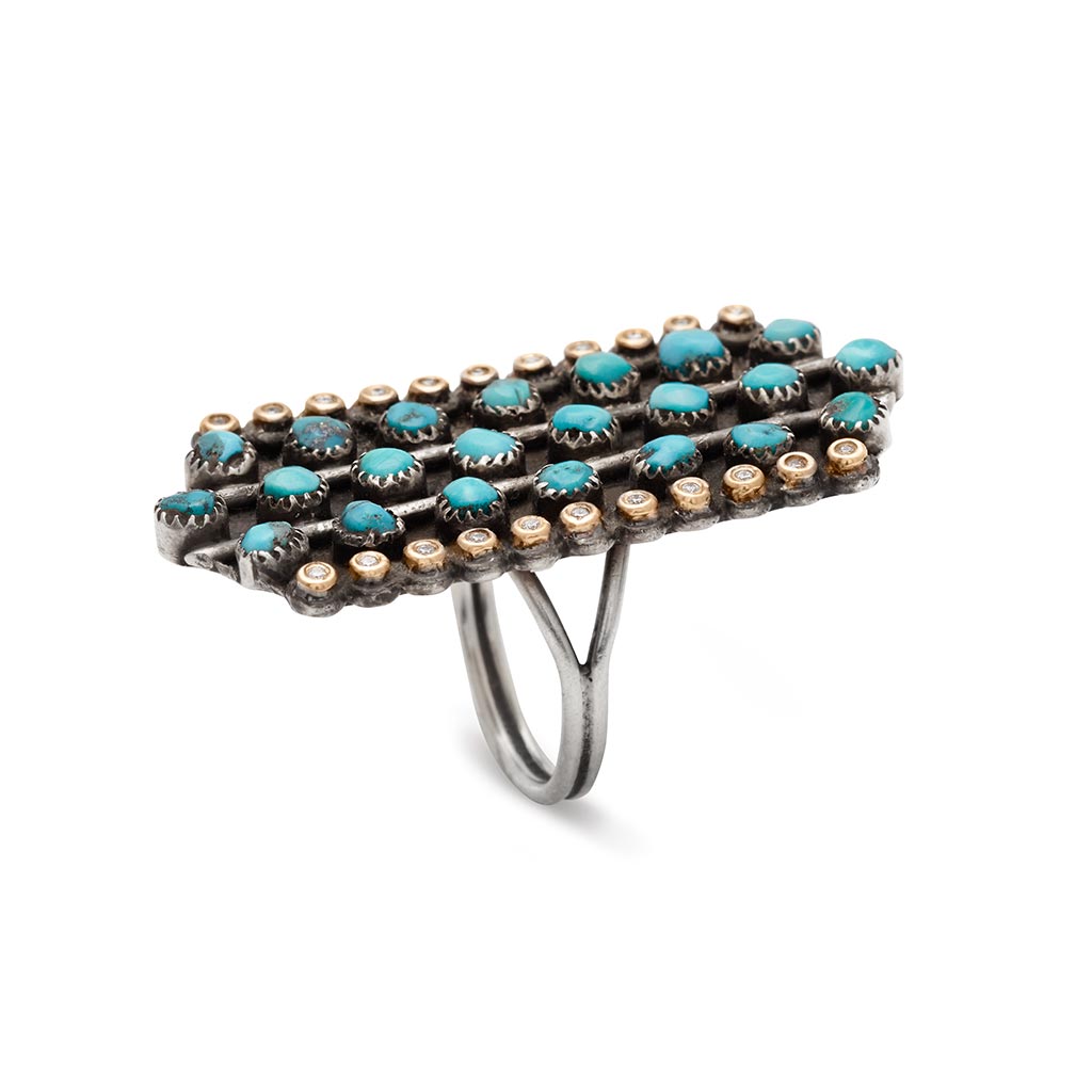 Side view of a rectangular shaped, one of a kind ring with turquoise and white diamond stones set in sterling silver.