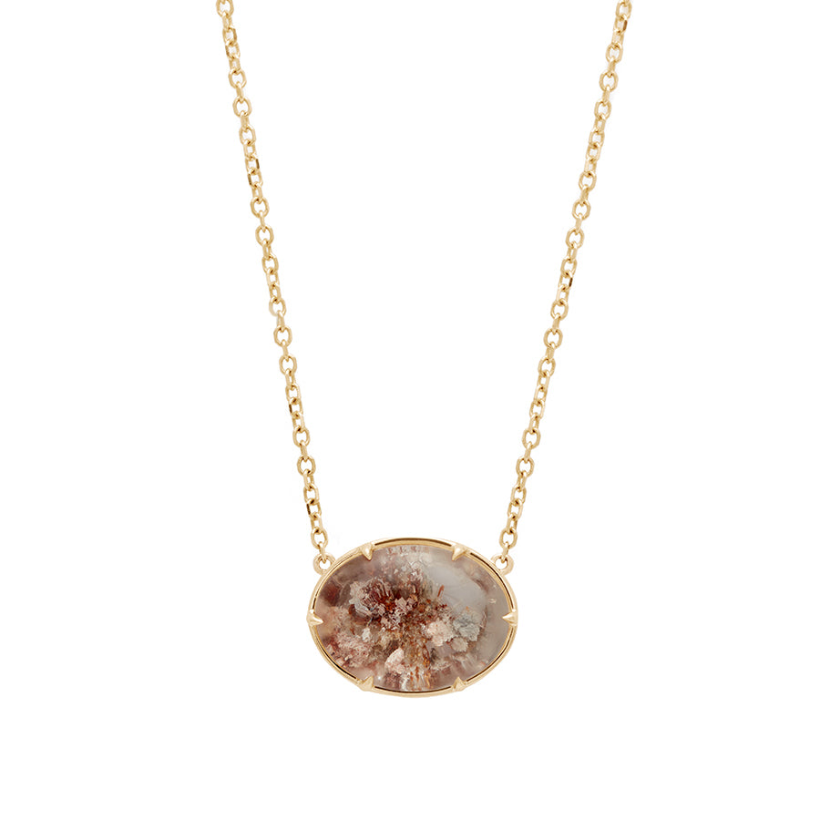 An oval quartz charm with a desert like scene in a bezel setting with claw prongs set in yellow gold on a yellow gold chain.