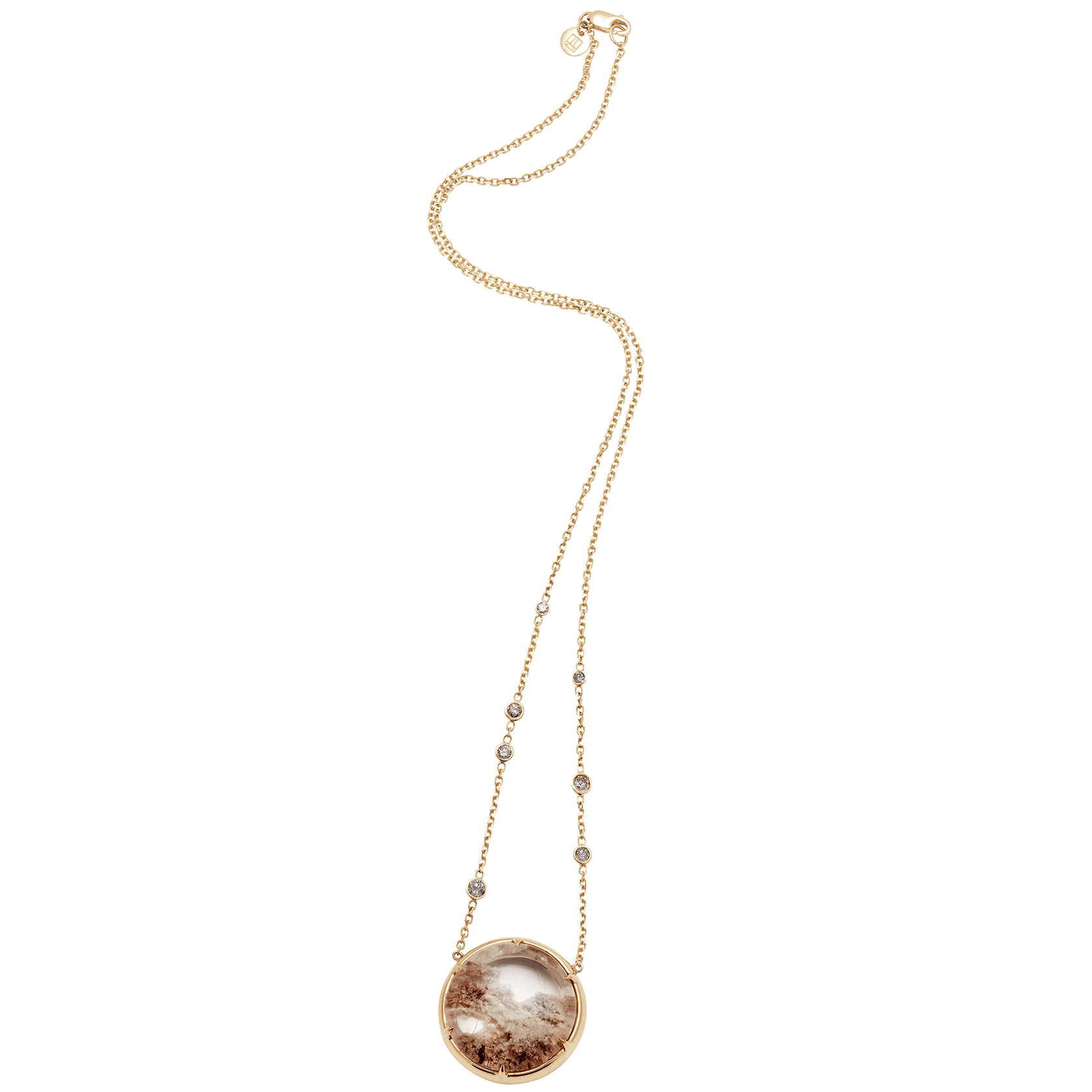 Zoomed out view of a quartz charm with a desert like scene in a bezel setting with claw prongs set in yellow gold on a yellow gold chain with grey diamonds on it.
