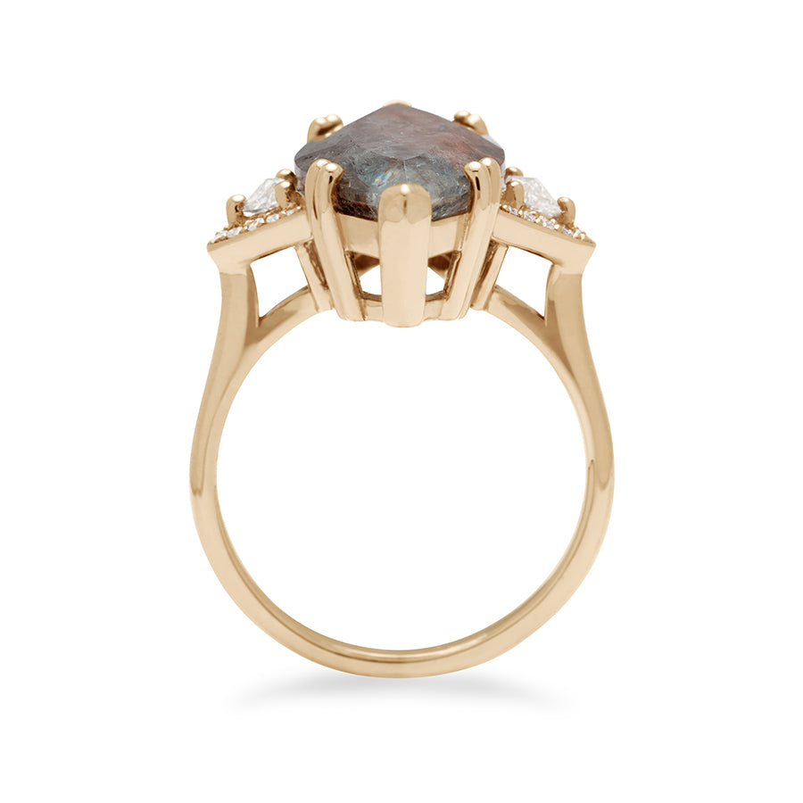 Side view of a marquise shaped ring with a quartz center stone with white diamond trillions with white diamond pave halo around them and set in yellow gold.