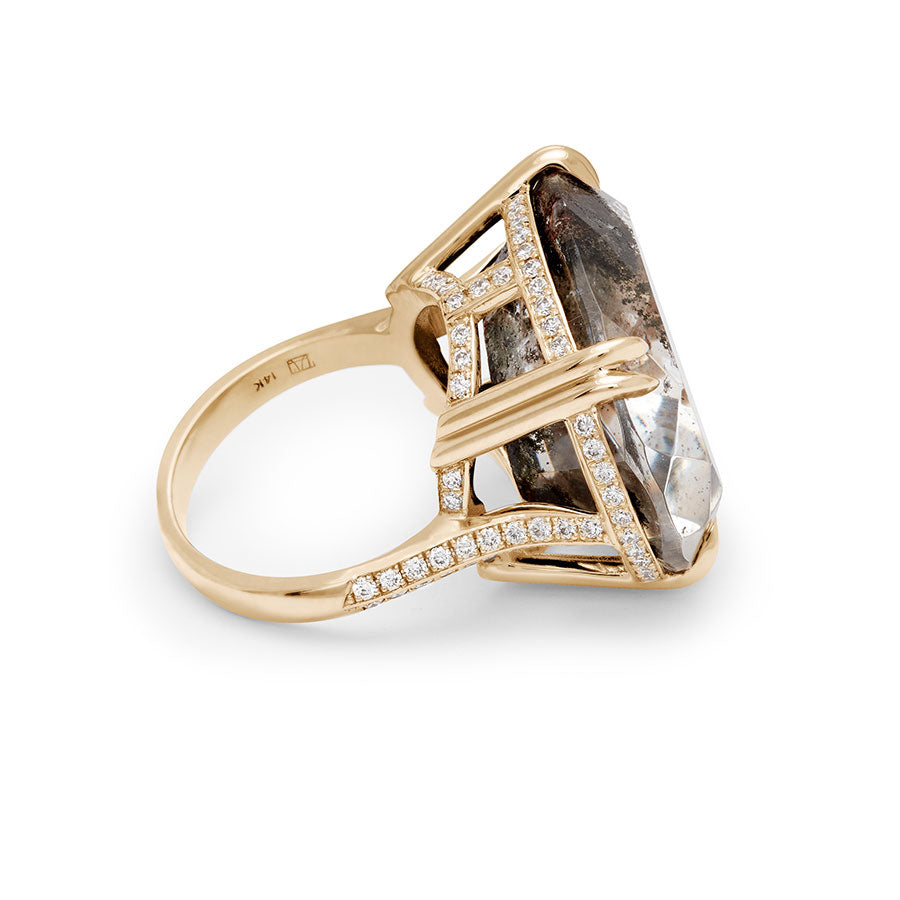 Angled view of an oval east/west set quartz ring set in yellow gold with white diamonds surrounding the underneath of the stone and band.