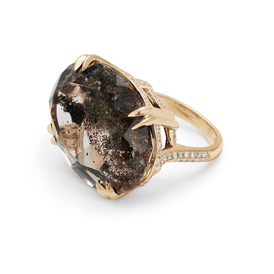 Angled view of an oval east/west set quartz ring set in yellow gold with white diamonds surrounding the underneath of the stone and band.