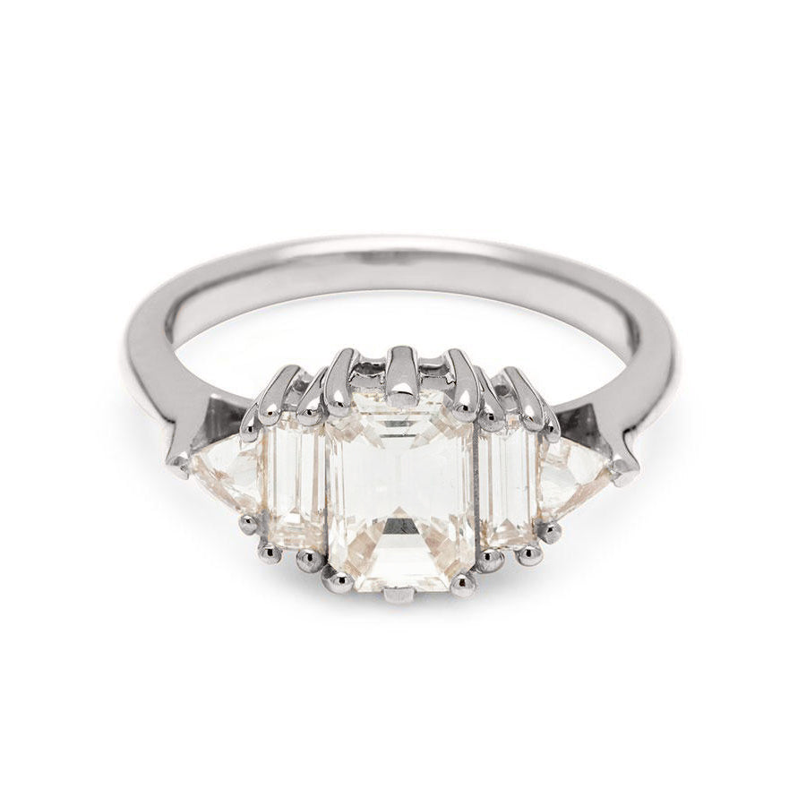 A ring with an emerald cut and shaped 1.00ct white diamond center stone with one baguette white diamond and one white diamond trillion on either side set in white gold., White Gold