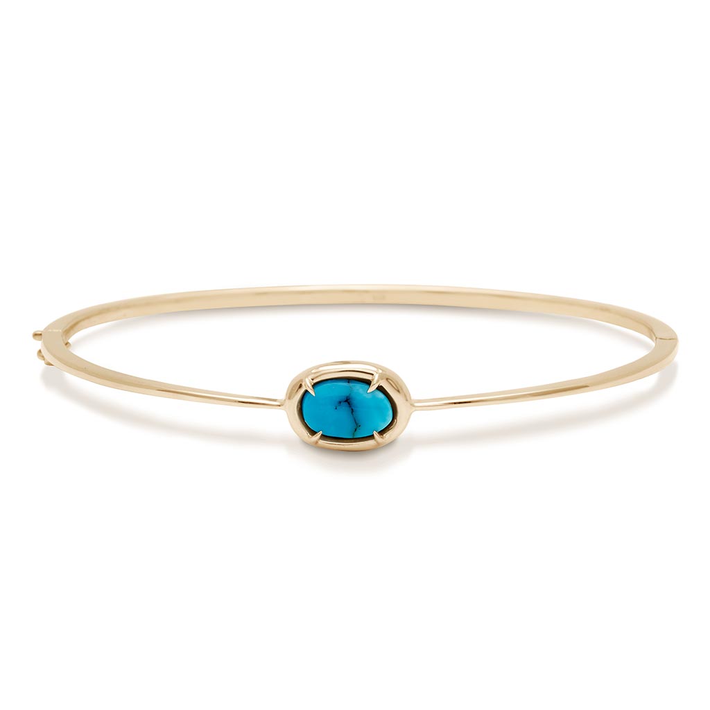 A bracelet with a bezel set turquoise stone with claw prongs set in yellow gold.