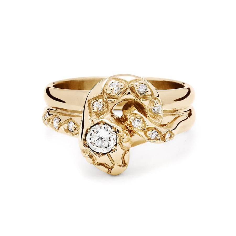 A serpent band with a white diamond center stone and white diamond accent stones around the head of the snake set in yellow gold., Yellow Gold