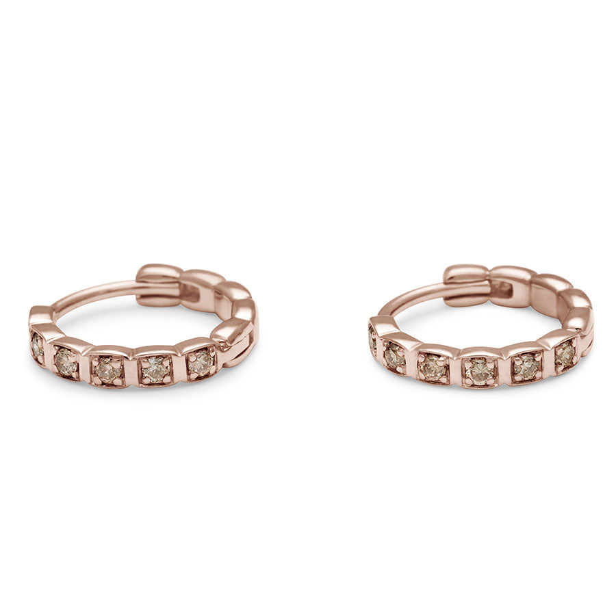 Side view of a gold pair of huggie hoops with champagne diamonds set in rose gold.