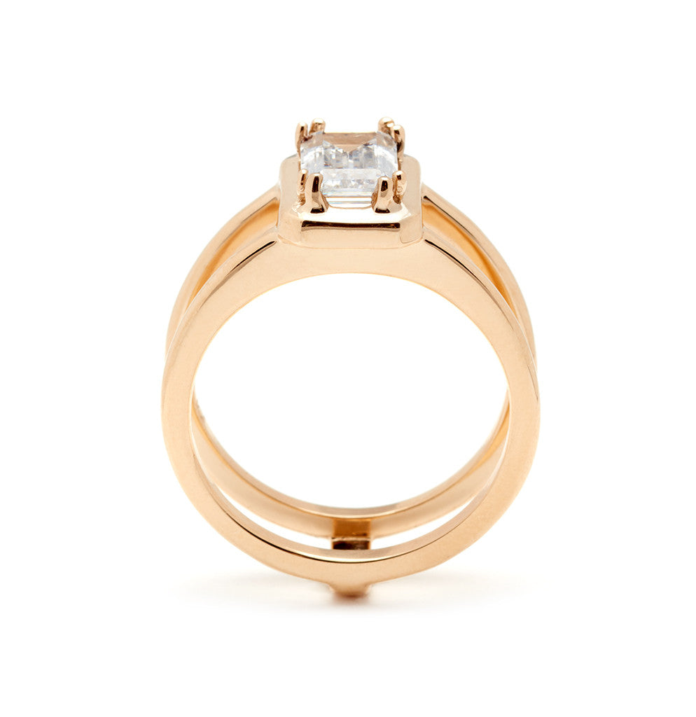 Side view of a double banded engagement ring with a white diamond emerald cut diamond set in yellow gold.