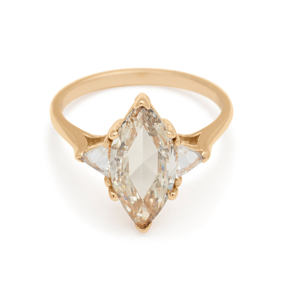A three stone engagement ring with a marquise shape 1.92ct champagne diamond center stone with two white diamond trillion side stones set in yellow gold.