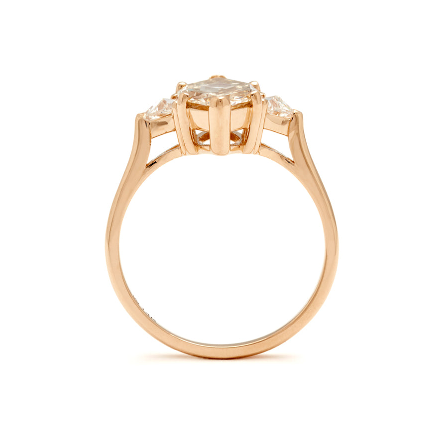 Side view of a three stone engagement ring with a marquise shape 1.92ct champagne diamond center stone with two white diamond trillion side stones set in yellow gold.