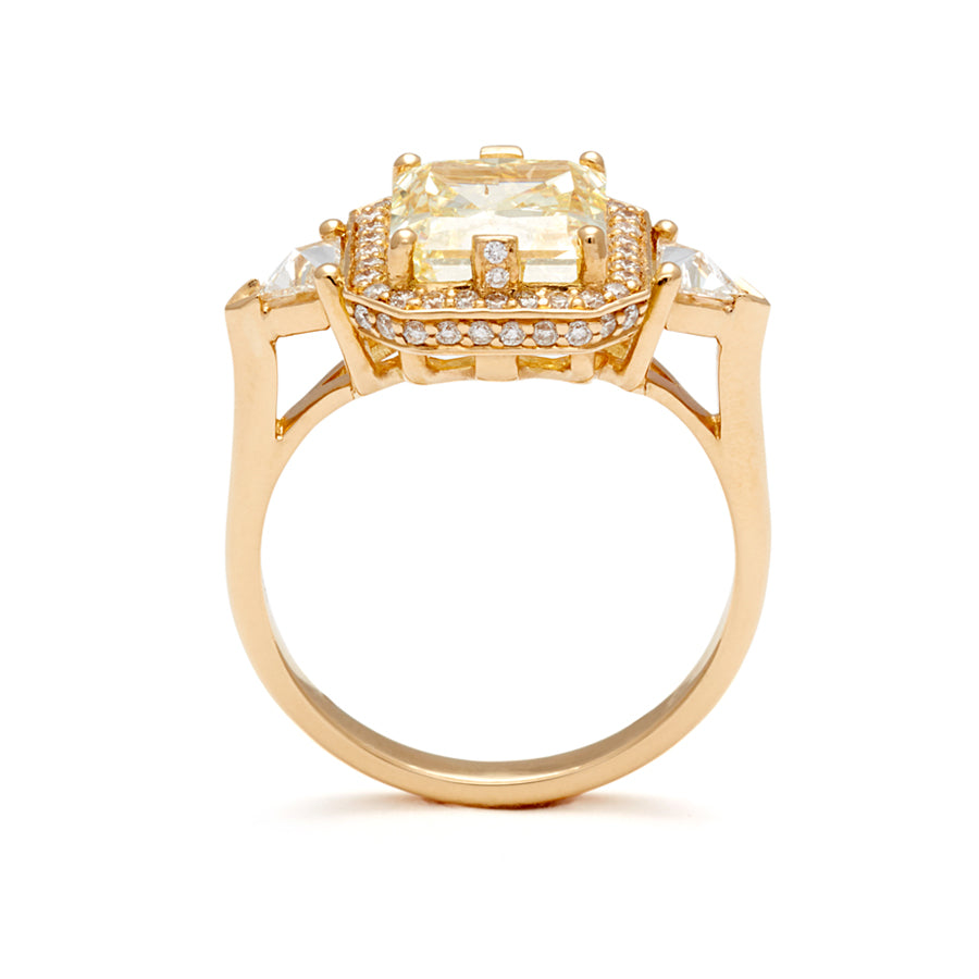 Side view of a three stone engagement ring with an radiant cut yellow diamond center stone surrounded by a white diamond pave halo with two white diamond trillion side stones set in yellow gold.
