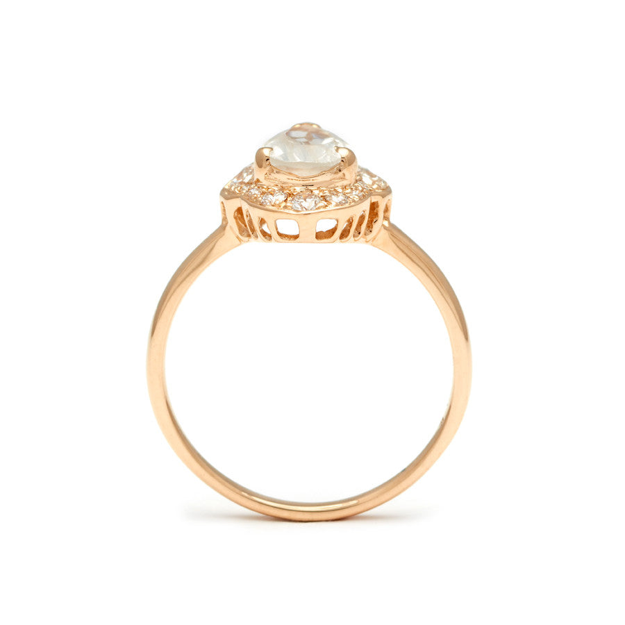 Side view of a pear shaped rainbow moonstone center ring set in a halo of white diamonds and in yellow gold.