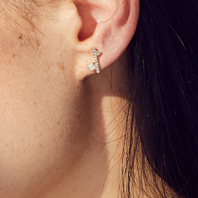 A single straight line of white diamond pave with an opal accent stones on one side earring set in yellow gold on a medium-complexion model's earring., White Gold, Rose Gold, Yellow Gold
