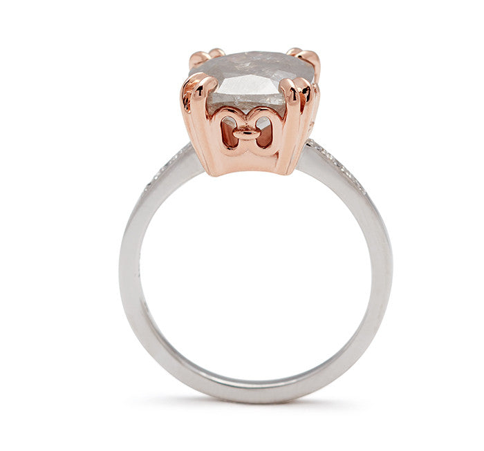 Side view of a solitaire ring with a cushion cut grey diamond with white diamond pave on either side set in white gold.